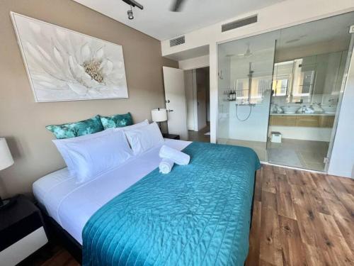 a bedroom with a large bed and a bathroom at Waterfront Escape 2Bdr, Wavepool, Restaurants in Darwin