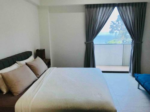 a bedroom with a large bed and a large window at 5 Stars Seafront Suite By The Sea 日落无敌全海景 5星 酒店等级 in Batu Ferringhi