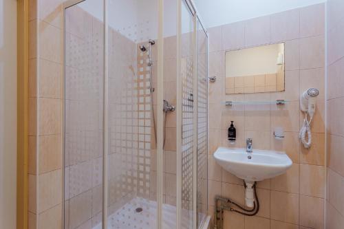 uma casa de banho com um chuveiro e um lavatório. em Black M - Penzión em Banská Štiavnica