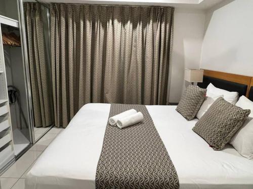a hotel room with a bed with a towel on it at Sky high with harbour views in Darwin