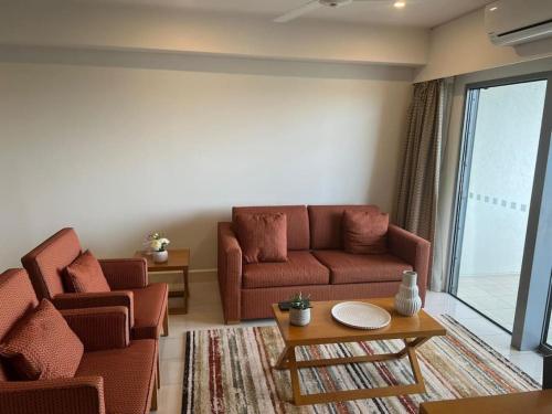 a living room with a couch and a table at Sky high with harbour views in Darwin