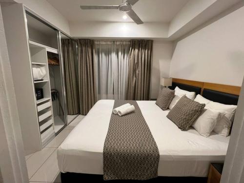 a bedroom with a large bed with a ceiling fan at Sky high with harbour views in Darwin