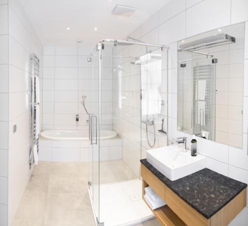 a white bathroom with a sink and a shower at Hotel Schloss Hernstein in Hernstein