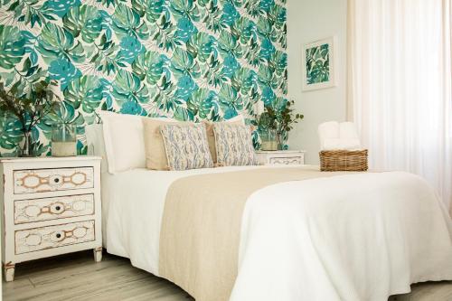um quarto com uma cama com papel de parede floral em Hostal Atalaya em Benalup Casas Viejas