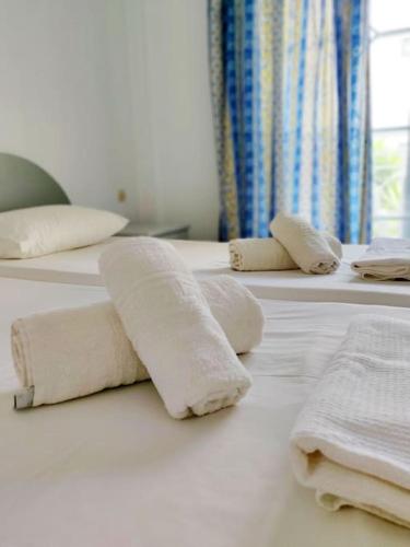 a row of white towels sitting on a bed at Atrium Apartment #3 in Karpathos