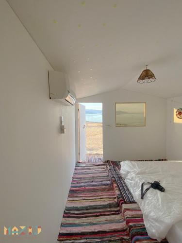 Mazih beach camp في نويبع: غرفة نوم مع سرير مع سجادة على الأرض
