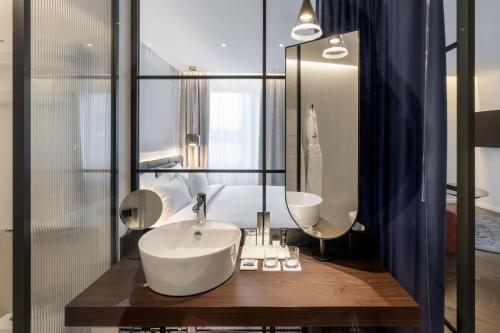 a bathroom with a sink and a large mirror at Radisson Collection Hotel, Santa Sofia Milan in Milan