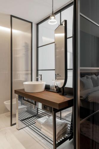 a bathroom with a sink and a mirror and a bed at Radisson Collection Hotel, Santa Sofia Milan in Milan