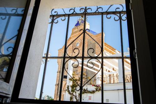 a building with a clock tower through a window at Hostal Benalup Atalaya in Benalup Casas Viejas