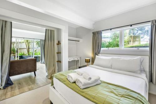 1 dormitorio con 1 cama blanca grande y ventana grande en A delight in the Bays - 1 BR - 1 BATH - Free WiFi, en Auckland