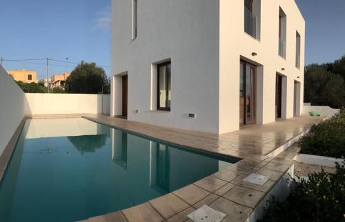 een huis met een zwembad naast een gebouw bij Casa cerca de Sant Francesc ET6394 in Sant Francesc Xavier