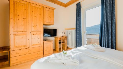 um quarto com uma cama e uma grande janela em HOTEL DOLOMITI di De Martin D Oscar em Comèlico Superiore