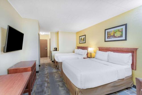 a hotel room with two beds and a flat screen tv at Wyndham Garden York in York