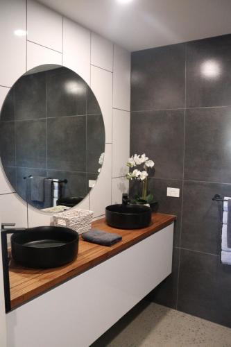 bagno con lavandino e specchio di Yarra Valley Stables Retreat a Gruyere
