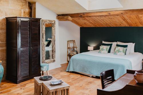 a bedroom with a large bed and a table at Le Coeur des Vignes in Pauillac