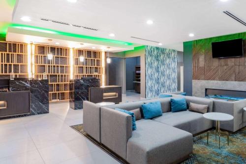 ein Wohnzimmer mit einem Sofa und einem TV in der Unterkunft La Quinta Inn & Suites by Wyndham Pharr RGV Medical Center in Pharr