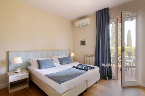 a bedroom with a bed with blue pillows and a window at Residence Poggio Golf Chianti Firenze in Impruneta