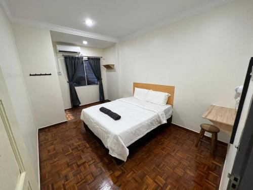 um quarto com uma cama com um edredão branco em Homestay Suria em Kuala Kangsar
