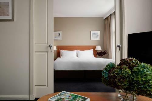 a hotel room with a bed and a table at Rydges Newcastle in Newcastle