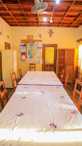 a large white bed in a room with chairs at Maison d'Accueil - Fondation San Filippo Neri in Bujumbura