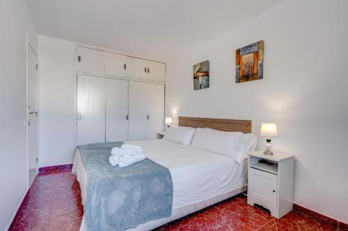 een slaapkamer met een wit bed en een nachtkastje bij Apto 111 El Dorado Playa las Americas By Paramount Holidays in Arona