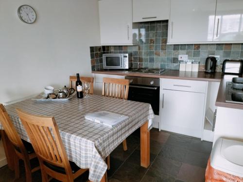 a kitchen with a table with chairs and a microwave at Bell Island Cottage in Whitby