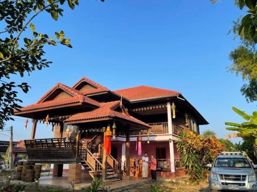 une maison avec un balcon et une voiture garée devant dans l'établissement House Lamphun Thai style, Near ChiangMai Airport, 