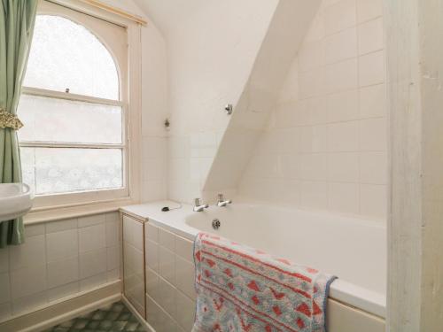 La salle de bains est pourvue d'une baignoire et d'une fenêtre. dans l'établissement Beaufort House, à Ilfracombe