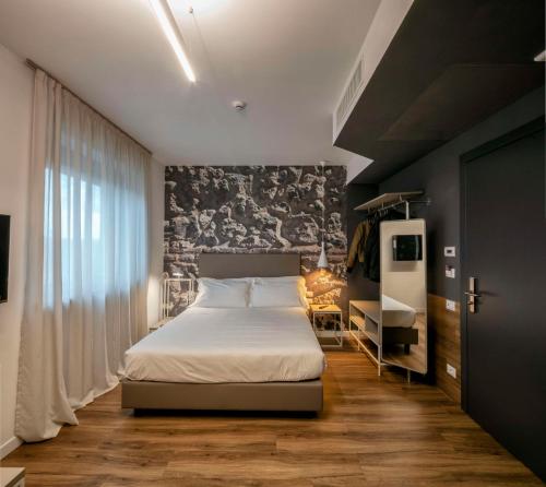 - une chambre avec un lit blanc et un mur noir dans l'établissement Best Western Hotel Corsi, à Torrimpietra