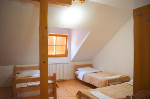 a attic room with two beds and a window at Mountain house Korab Trnica in Trnica