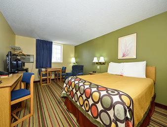 a hotel room with a bed and a desk at Super 8 by Wyndham Minot Airport in Minot