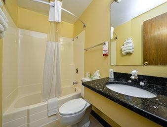 a bathroom with a sink and a toilet and a tub at Super 8 by Wyndham Minot Airport in Minot