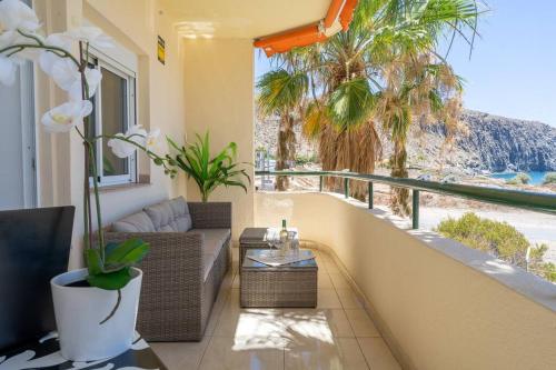 a balcony with a couch and a view of the ocean at Apartment in front of the ocean in Los Cristianos