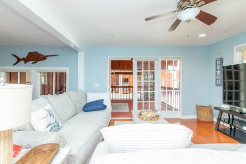 sala de estar con sofá blanco y ventilador de techo en Tampa Bay Getaway with Pool & Boat en Riverview