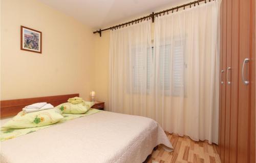 Gorgeous Apartment In Orebic With Wifi في أوربيك: غرفة نوم بسرير وملاءات بيضاء ونافذة