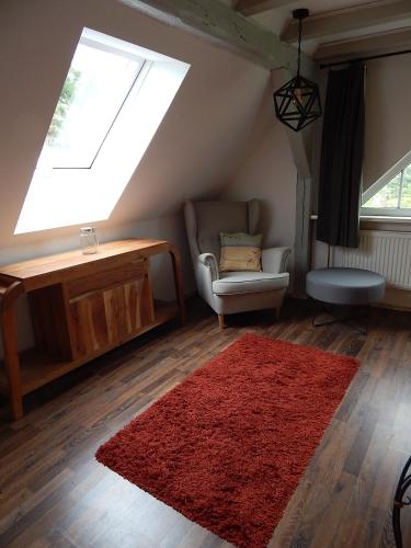 a living room with a red rug and a window at LANDHAUS LAAVE FERIENWOHNUNG in Laave
