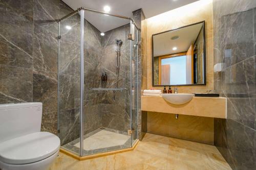 a bathroom with a shower and a toilet and a sink at Wyndham Garden Grandworld Phu Quoc in Phu Quoc