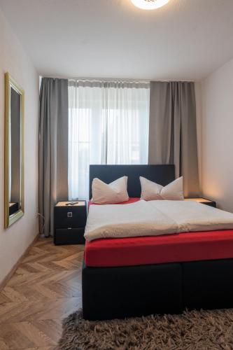 a bedroom with a bed with a large window at Hotel Ammerland garni in Wilhelmshaven