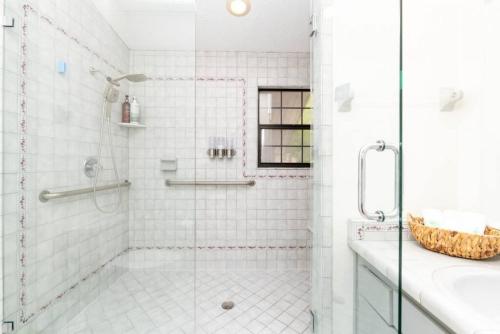 La salle de bains blanche est pourvue d'une douche et d'un lavabo. dans l'établissement Stunning Tampa Bay Waterfront House with Pool & Boat, à Riverview