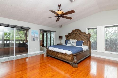 1 dormitorio con 1 cama y ventilador de techo en Stunning Tampa Bay Waterfront House with Pool & Boat, en Riverview