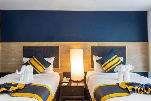 two beds sitting next to each other in a bedroom at Diamond Cottage Resort & Spa in Karon Beach