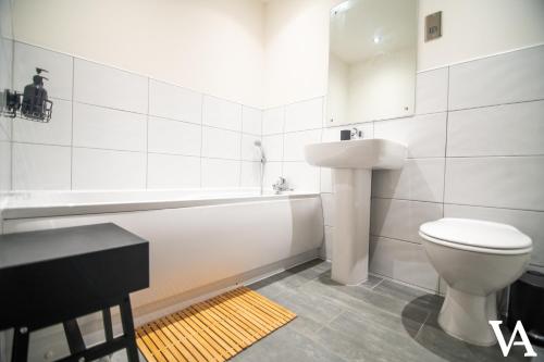 La salle de bains blanche est pourvue de toilettes et d'un lavabo. dans l'établissement Velvet Apartments - Conditioning House, à Bradford