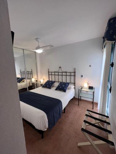a bedroom with two beds and a mirror at Apartamento Zahara in Zahara de los Atunes