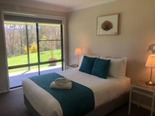 a bedroom with a large bed with a large window at Kangoo - Peacefull tree lined property, wildlife in Mount View