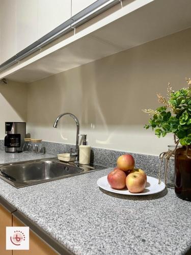 a plate of apples on a counter in a kitchen at Jhezzstuffs staycation in Iloilo City