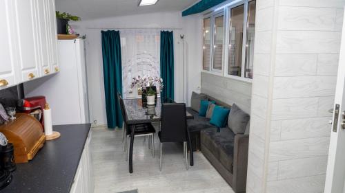 - une salle à manger avec une table et un canapé dans l'établissement Casa Sebastian, à Costinesti
