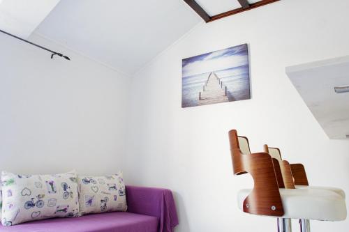 a living room with a purple couch and a guitar at Villa Mali Raj in Zaton