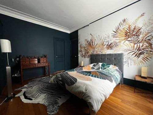 superbe appartement belifontain coeur de ville في فونتينبلو: غرفة نوم مع سرير حمار وحشي مع لوحة على الحائط