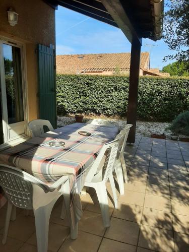 una mesa blanca y sillas en un patio en Maison de 2 chambres avec piscine partagee jardin clos et wifi a Eyguieres, en Eyguières