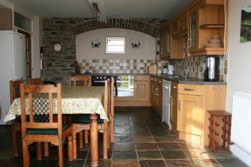 een keuken met een tafel en stoelen en een aanrecht bij StoneyAcre in Keswick